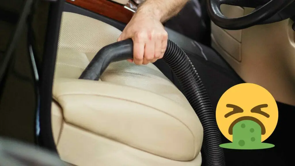 Photo of a person vacuuming a perforated leather seat with an emoji on top of it vomiting.