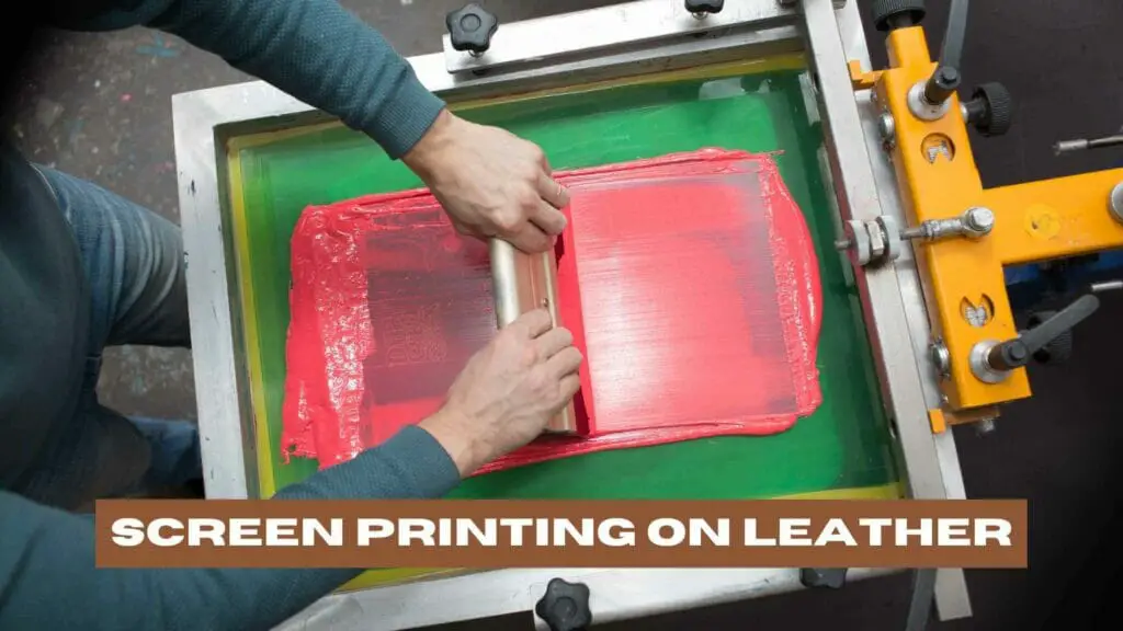 Photo of a person doing screen printing on black leather with red paint. Screen Printing on Leather.