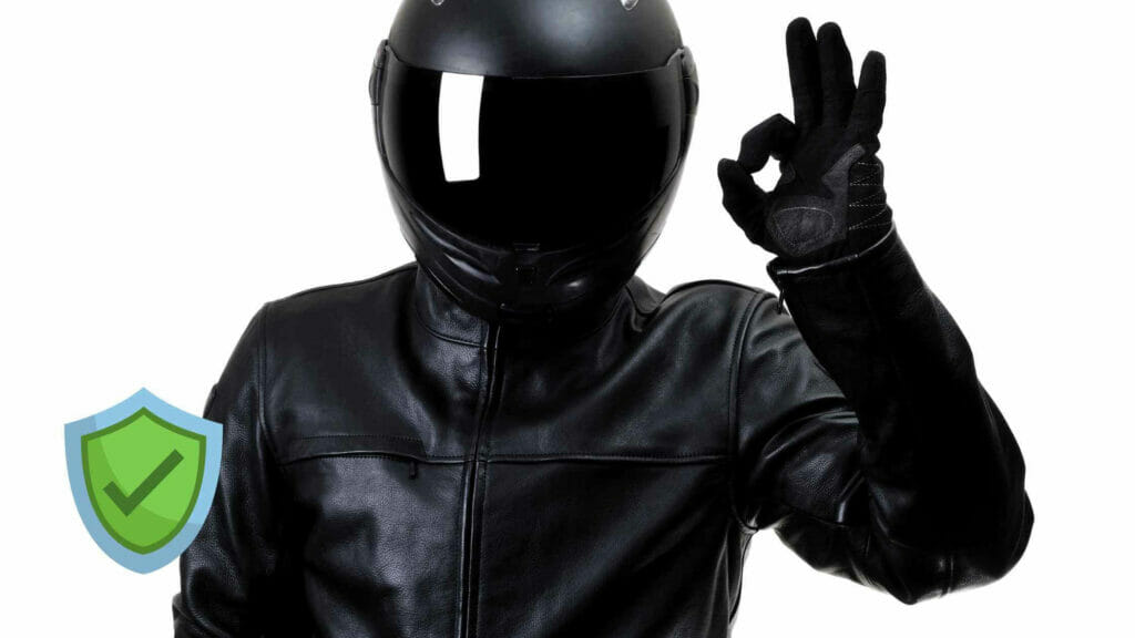 Biker wearing a black helmet, a leather jacket and leather gloves.